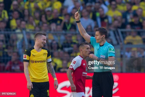 The referee shows a yellow card to Marco Reus of Dortmund during the Bundesliga match between Borussia Dortmund and 1. FSV Mainz 05 at Signal Iduna...