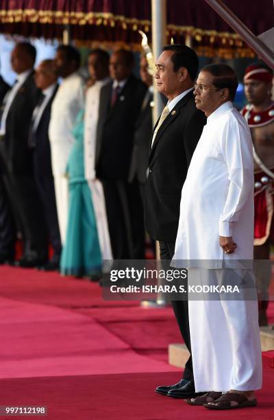 Thai Prime Minister Prayut Chan-O-Cha and Sri Lankan President Maithripala Sirisena stand at attention during a welcoming ceremony at the...