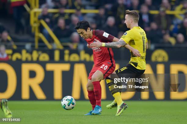 Makoto Hasebe of Frankfurt and Marco Reus of Dortmund battle for the ball during the Bundesliga match between Borussia Dortmund and Eintracht...