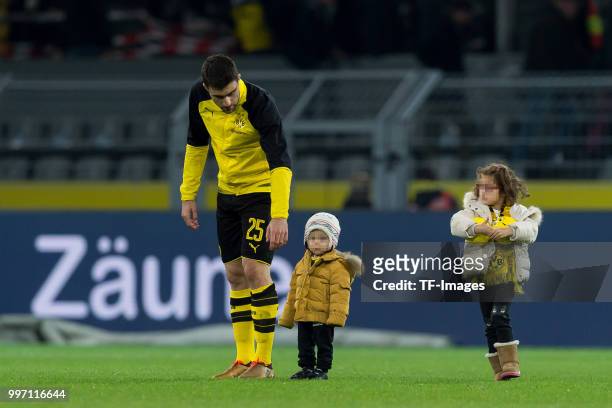 Sokratis Papastathopoulos of Dortmund and two children walk on the field after the Bundesliga match between Borussia Dortmund and Eintracht Frankfurt...