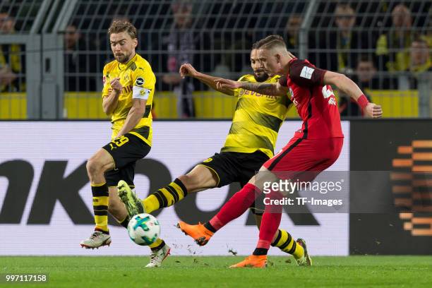 Marcel Schmelzer of Dortmund, Oemer Toprak of Dortmund and Marius Wolf of Frankfurt battle for the ball during the Bundesliga match between Borussia...