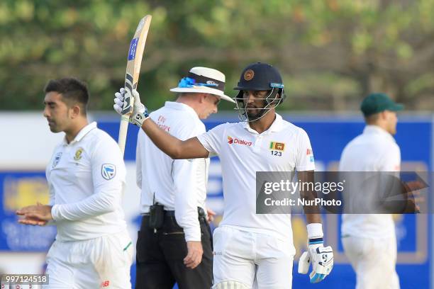 Sri Lankan cricketer Dimuth Karunaratne celebrates after scoring 150 runs during the first day's play in the 1st Test cricket match between Sri Lanka...