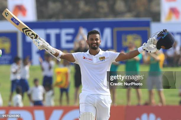 Sri Lankan cricketer Dimuth Karunaratne celebrates after scoring 100 runs during the 1st Day's play of the 1st Test match between Sri Lanka and South...