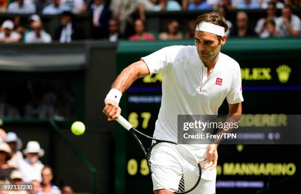 Roger Federer of Switzerland in action against Adrian Mannarino of France in the fourth round of the gentlemen's singles at the All England Lawn...