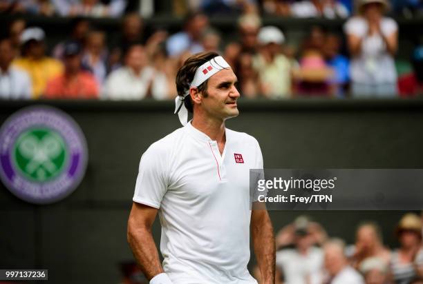 Roger Federer of Switzerland smiles at his team after beating Adrian Mannarino of France in the fourth round of the gentlemen's singles at the All...