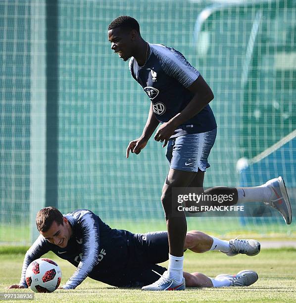 France's midfielder Paul Pogba jokes with France's forward Antoine Griezmann during a training session at the Glebovets stadium in Istra, some 70 km...