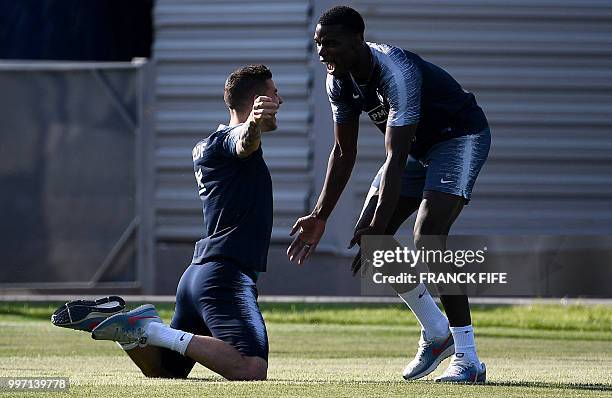 France's midfielder Paul Pogba jokes with France's defender Lucas Hernandez during a training session at the Glebovets stadium in Istra, some 70 km...