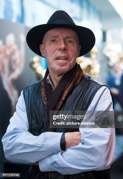 Plastinator Gunther von Hagens standing in front of a gold-plated plastinated figure in the Menschen Museum during a press conference on the museum's...