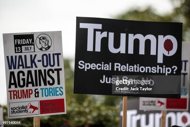 Protesters hold placards during a demonstration outside Winfield House, the London residence of US ambassador Woody Johnson, where US President...