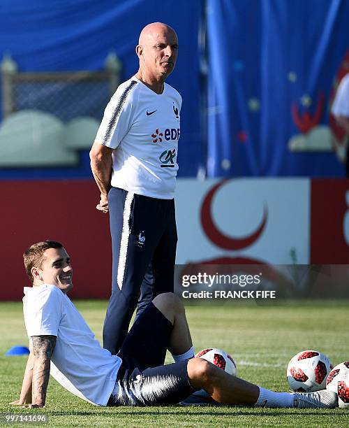 France's forward Antoine Griezmann and assistant coach Guy Stephan attend a training session at the Glebovets stadium in Istra, some 70 km west of...