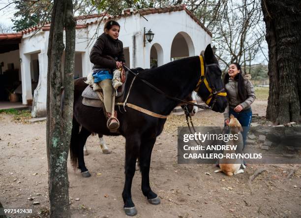 Traditioanl Gouchas, female horse riders, take a break near a house on a farm in the town of Jose de la Quintana, in Cordoba province on July 3,...