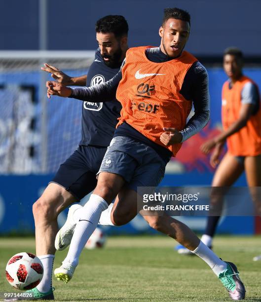 France's midfielder Corentin Tolisso vies with France's defender Adil Rami during a training session at the Glebovets stadium in Istra, some 70 km...