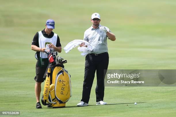 Steve Wheatcroft speaks with his caddie on the 17th hole during the first round of the John Deere Classic at TPC Deere Run on July 12, 2018 in...