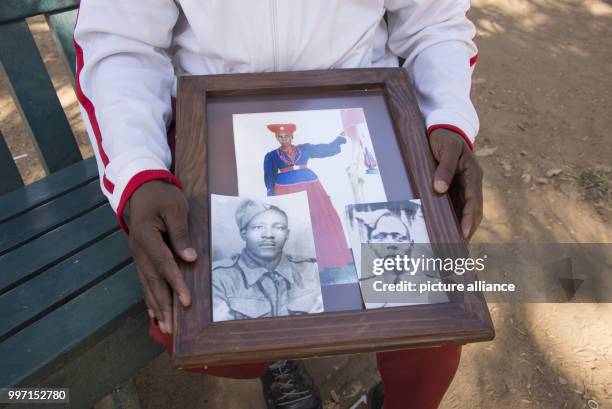 Uruanaani Scara Matundu, a representative of the Herero community, showing pictures of his ancestors in a park in Windhoek, Namibia, 12 May 2017. His...