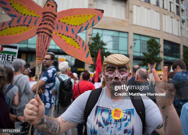 Man wears a Donald Trump mask as protestors gather outside Cardiff Library on the Hayes in Cardiff to protest against a visit by the President of the...