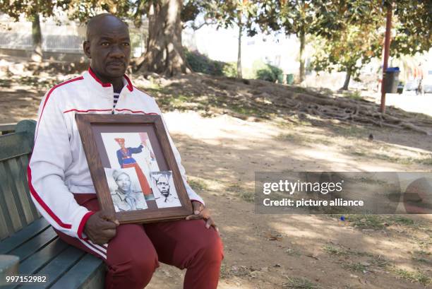 Uruanaani Scara Matundu, a representative of the Herero community, showing pictures of his ancestors in a park in Windhoek, Namibia, 12 May 2017. His...