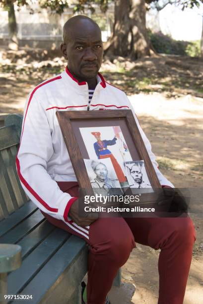 Uruanaani Scara Matundu, a representative of the Herero community, showing pictures of his ancestors in a park in Windhoek, Namibia, 12 May 2017. His...