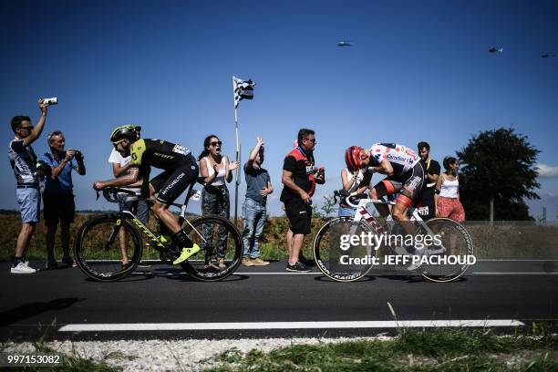 Spectators cheer as New Zealand's Jack Bauer and Latvia's Toms Skujins, wearing the best climber's polka dot jersey, pedal following the first ascend...