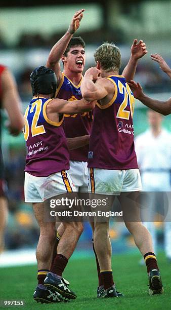 Jonathan Brown, Shaun Hart and Craig Bolton of Brisbane celebrate winning against Melbourne during the AFL round 12 match between the Brisbane Lions...