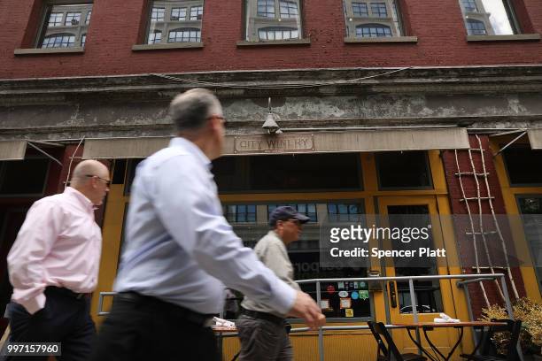People pass the wine bar and music venue City Winery in lower Manhattan on July 12, 2018 in New York City. The Walt Disney Co., which has announced...