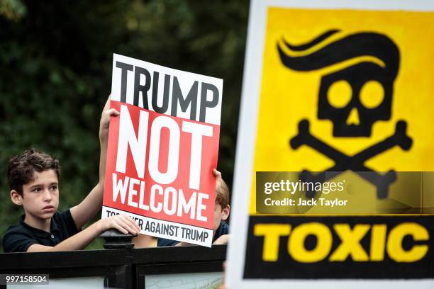 Protesters hold placards during a demonstration outside Winfield House, the London residence of US ambassador Woody Johnson, where US President...