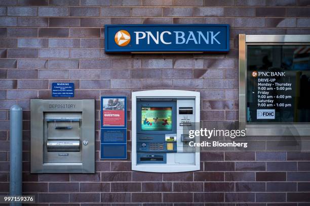 Signage is displayed above an automatic teller machine at the drive-thru lane of a PNC Financial Services Group Inc. Bank branch in Chicago,...