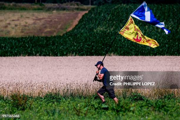 Spectator waves the Scottish flag and the Royal Banner of Scotland along the route during the sixth stage of the 105th edition of the Tour de France...