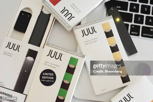 Juul Labs Inc. E-cigarette, USB charger, and flavored pods are arranged for a photograph in the Brooklyn Borough of New York, U.S., on Sunday July 8,...