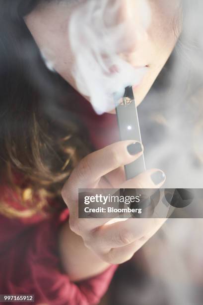 Person smokes a Juul Labs Inc. E-cigarette in this arranged photograph taken in the Brooklyn Borough of New York, U.S., on Sunday July 8, 2018. Juul...