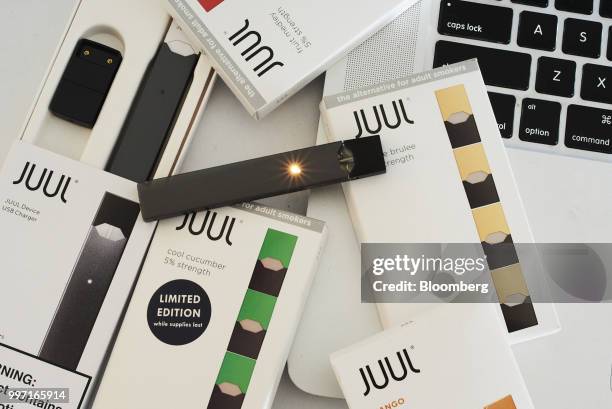 Juul Labs Inc. E-cigarette, USB charger, and flavored pods are arranged for a photograph in the Brooklyn Borough of New York, U.S., on Sunday July 8,...