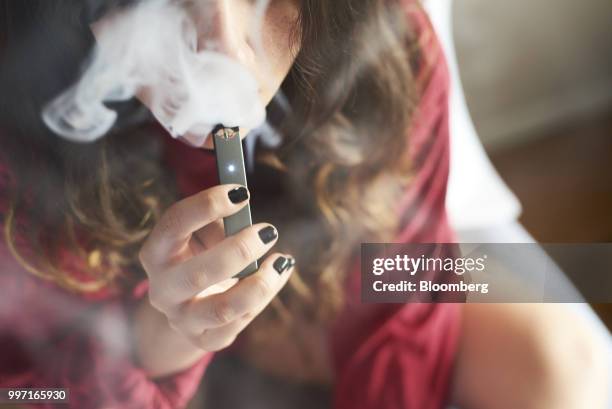 Person smokes a Juul Labs Inc. E-cigarette in this arranged photograph taken in the Brooklyn Borough of New York, U.S., on Sunday July 8, 2018. Juul...