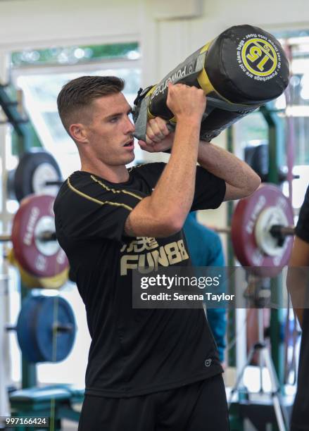 Ciaran Clark lifts weight bags during the Newcastle United Training session at Carton House on July 12 in Kildare, Ireland.