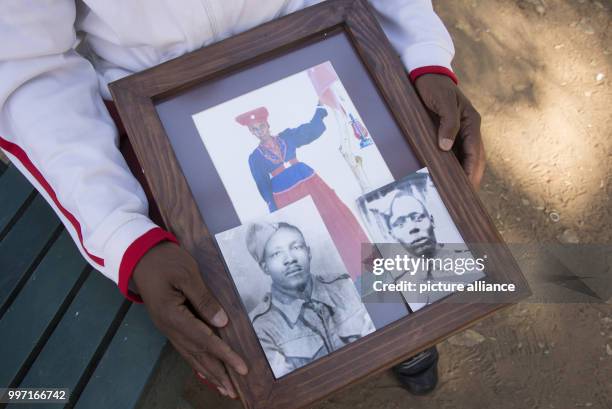 Uruanaani Scara Matundu, a representative of the Herero community can be seen with a photograph of his ancestor at a part in Windhuk, Namibia, 13 May...