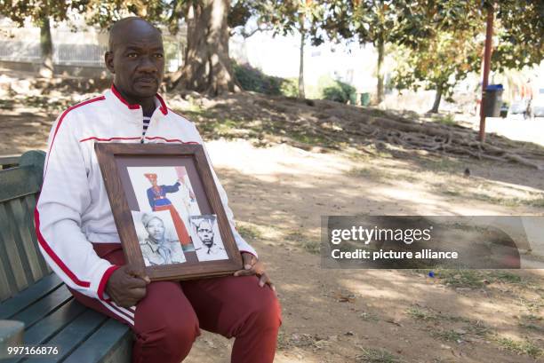 Uruanaani Scara Matundu, a representative of the Herero community can be seen with a photograph of his ancestor at a part in Windhuk, Namibia, 13 May...