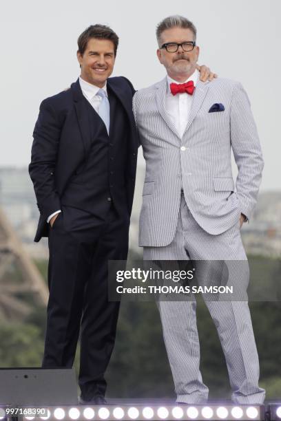 Film director Christopher McQuarrie and US actor Tom Cruise pose in front of the Eiffel Tower after the world premiere of the film Mission:...