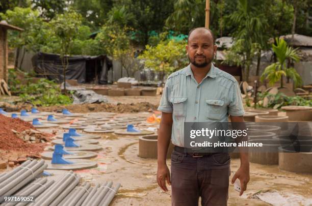 Ubaidul Hanna stands next to his products in Cox's Bazar, Bangladesh, 6 October 2017. He sells toilets, bamboo and plastic material to Rohingya...
