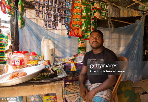 Mohammed Budu, who himself isn't Rohingya or a refugee, sits inside his small store in Cox's Bazar, Bangladesh, 6 October 2017. He recently moved to...