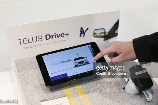 An employee points to a screen advertising the Telus Drive+ app at a Telus Corp. Store in Toronto, Ontario, Canada, on Monday, July 9, 2018. Telus...