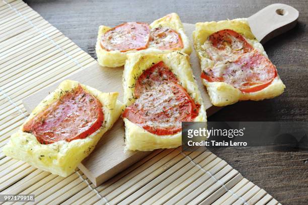 puff pastry pizzas with tomatoes and origan - origan stock-fotos und bilder