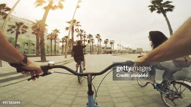 pov bicycle riding with friends at barceloneta beach in barcelona, spain - 666 stock pictures, royalty-free photos & images