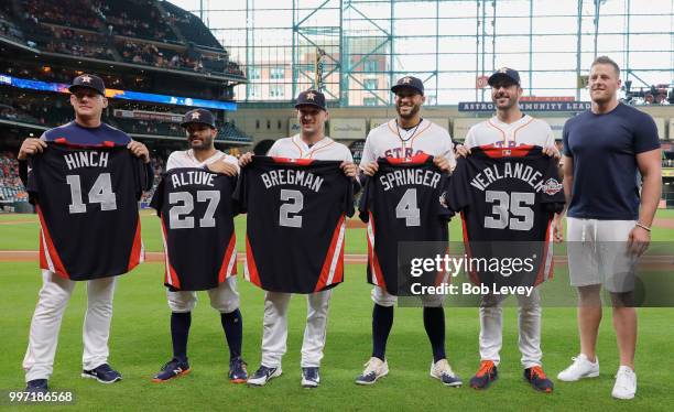 Houston Texan J.J. Watt, right, presents manager AJ Hinch,Jose Altuve,Alex Bregman, George Springer and Justin Verlander with their 2018 All-Star...