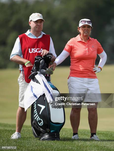 Alicia Dibos of Peru stands with her caddie on the eighth hole during the first round of the U.S. Senior Women's Open at Chicago Golf Club on July...