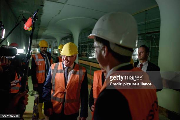 President Frank-Walter Steinmeier wearing a helmet and safety vest standing in the construction site of the U-Bahn station "Rotes Rathaus" on the...