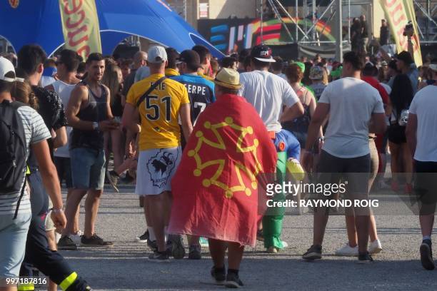 Man wrapped in an Occitan flag walks during the Electro Beach festival in Barcares, southern France on July 12, 2018.
