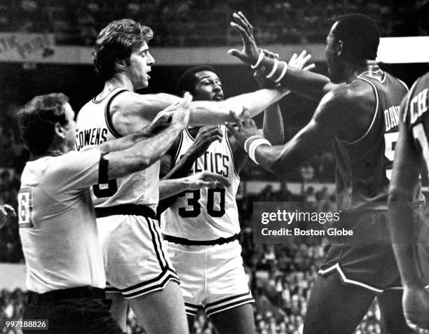 Boston Celtics' Dave Cowens and referee Walter Rooney break up the Celtics' M.L. Carr and Philadelphia's Darryl Dawkins during the second quarter of...