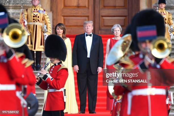 Britain's Prime Minister Theresa May US President Donald Trump and his wife US First Lady Melania Trump stand on steps in the Great Court watching...