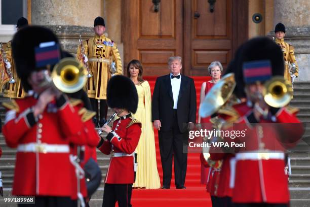 Britain's Prime Minister Theresa May, U.S. President Donald Trump and First Lady Melania Trump look on as a military band plays at Blenheim Palace on...