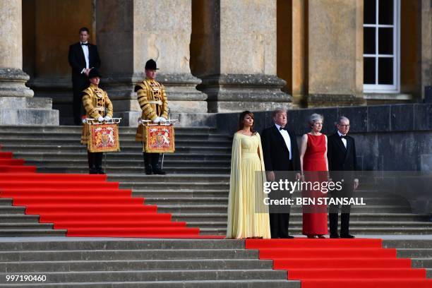 First Lady Melania Trump, US President Donald Trump, Britain's Prime Minister Theresa May and her husband Philip May stand on steps in the Great...