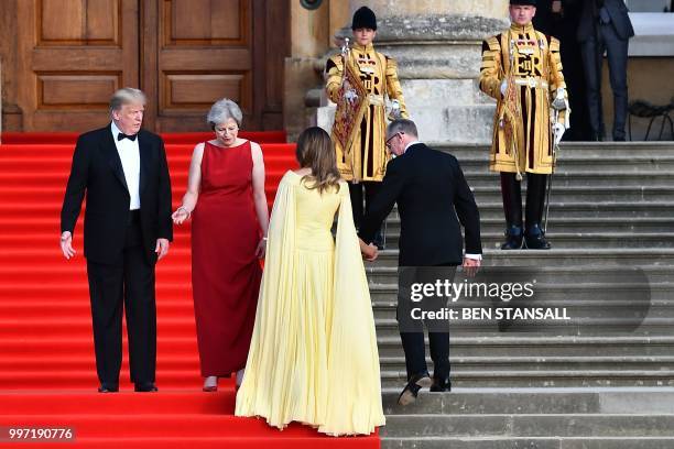 President Donald Trump, Britain's Prime Minister Theresa May, US First Lady Melania Trump and Philip May take their positions on the steps in the...