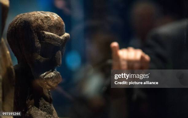 Man pointing to a wooden figure from the early 19th century during a press tour of the exhibition "Hawai'i - Royal Island in the Pacific" in the...